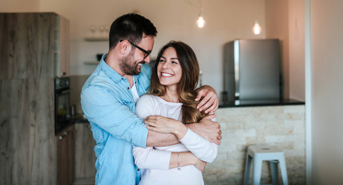 A couple embracing while smiling