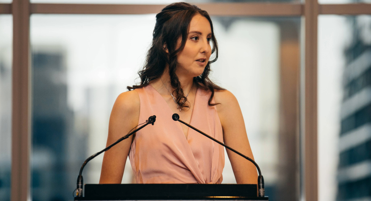 Emma standing at a podium