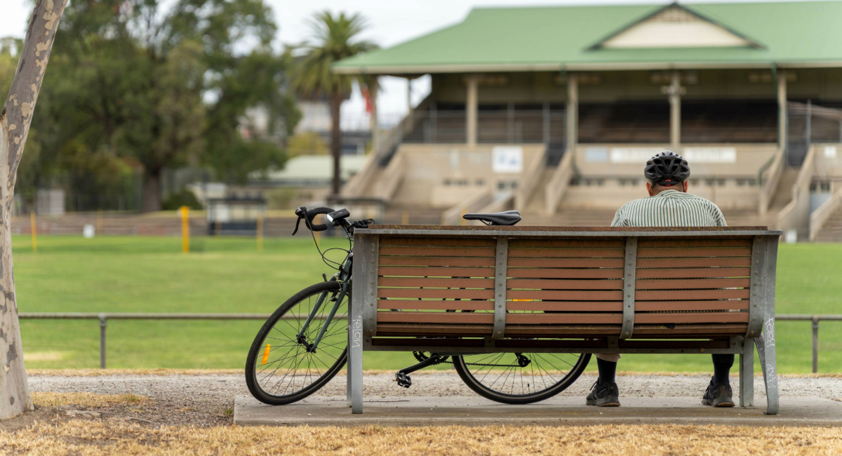 A man sitting alone on a bench outside