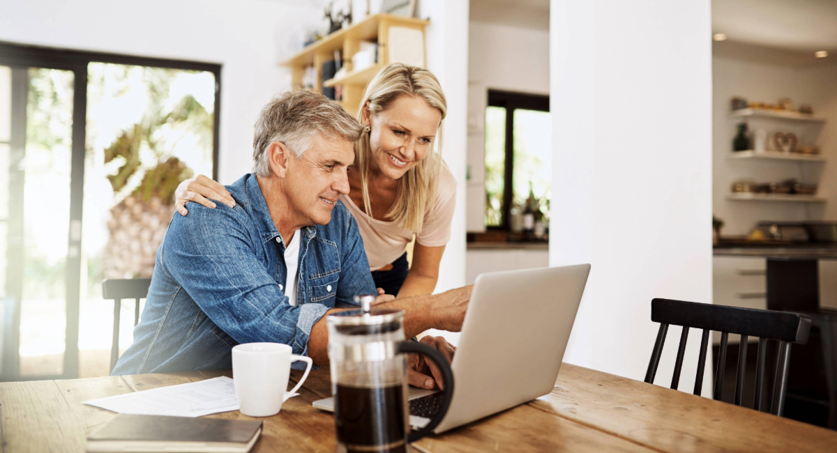 An older couple looking at a laptop