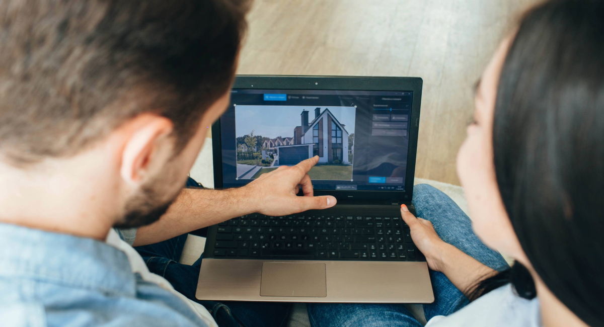 A couple looking at a house on a laptop