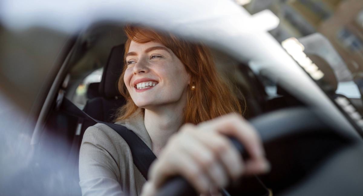 A young woman sitting in her new car