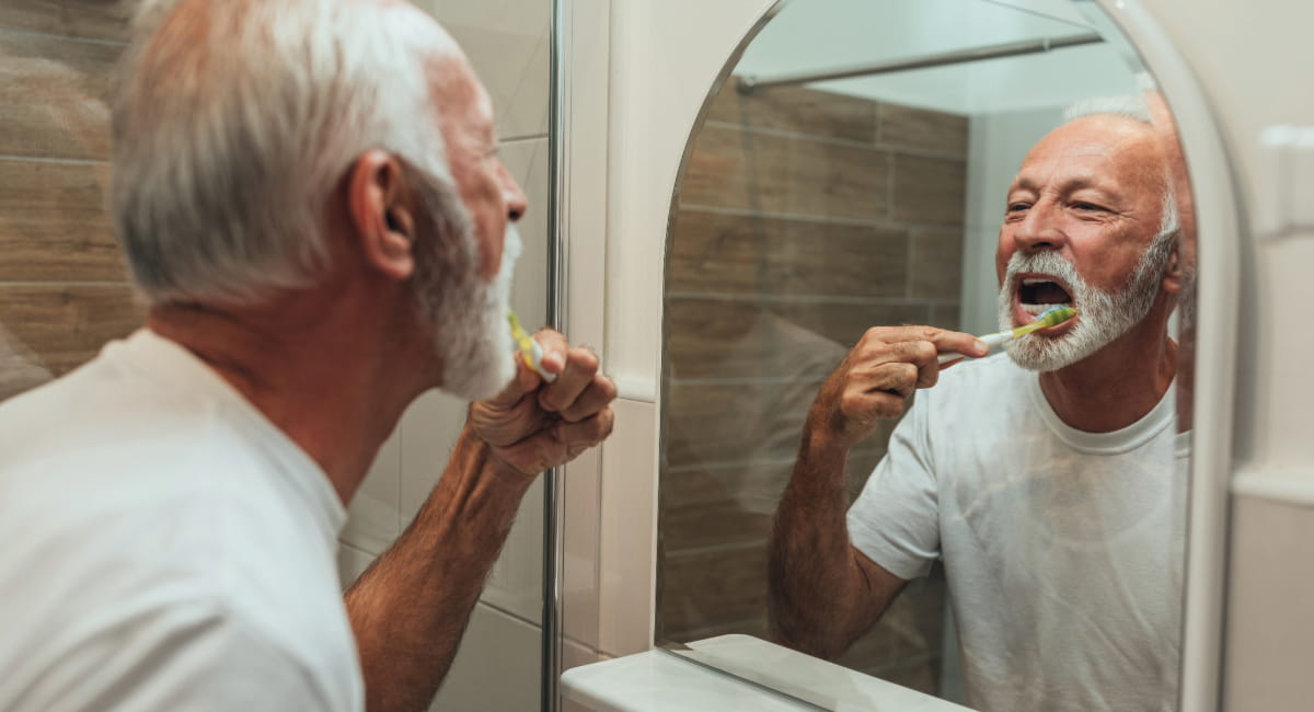 An elderly man brushing his teeth