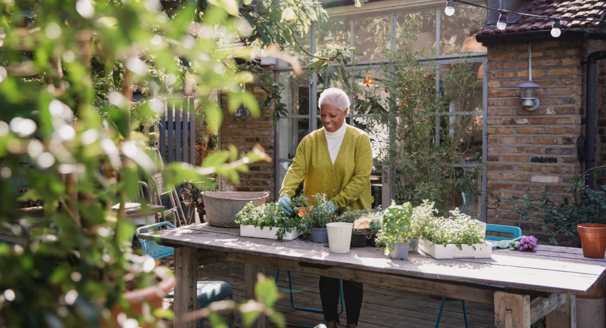 An older woman in her backyard gardening