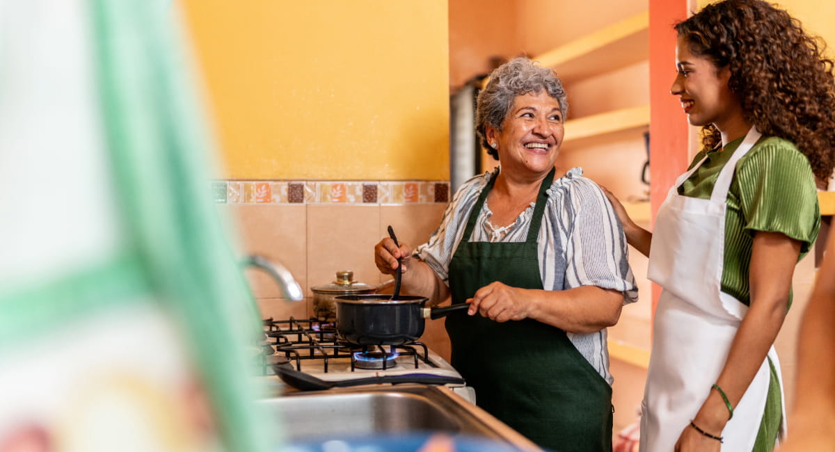 An older man with his grandson watering a tree in the backyard