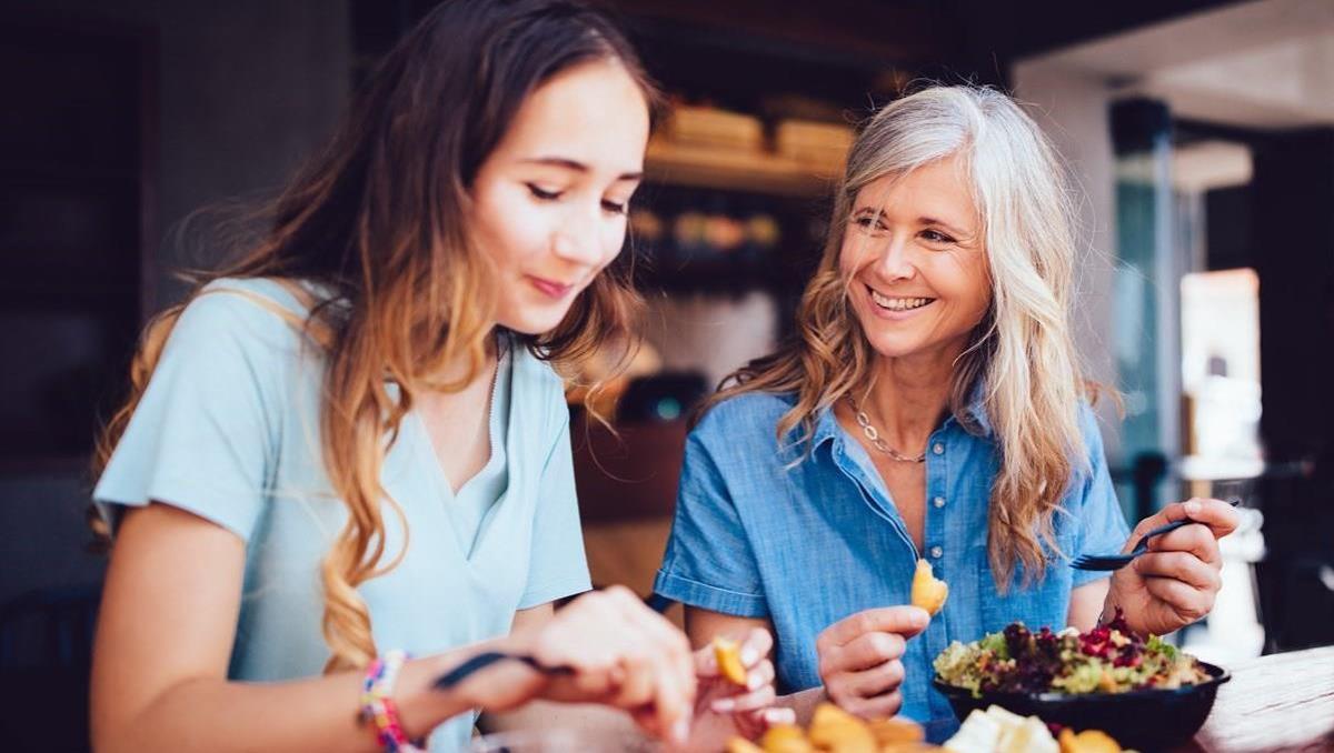 Two women smiling and eating