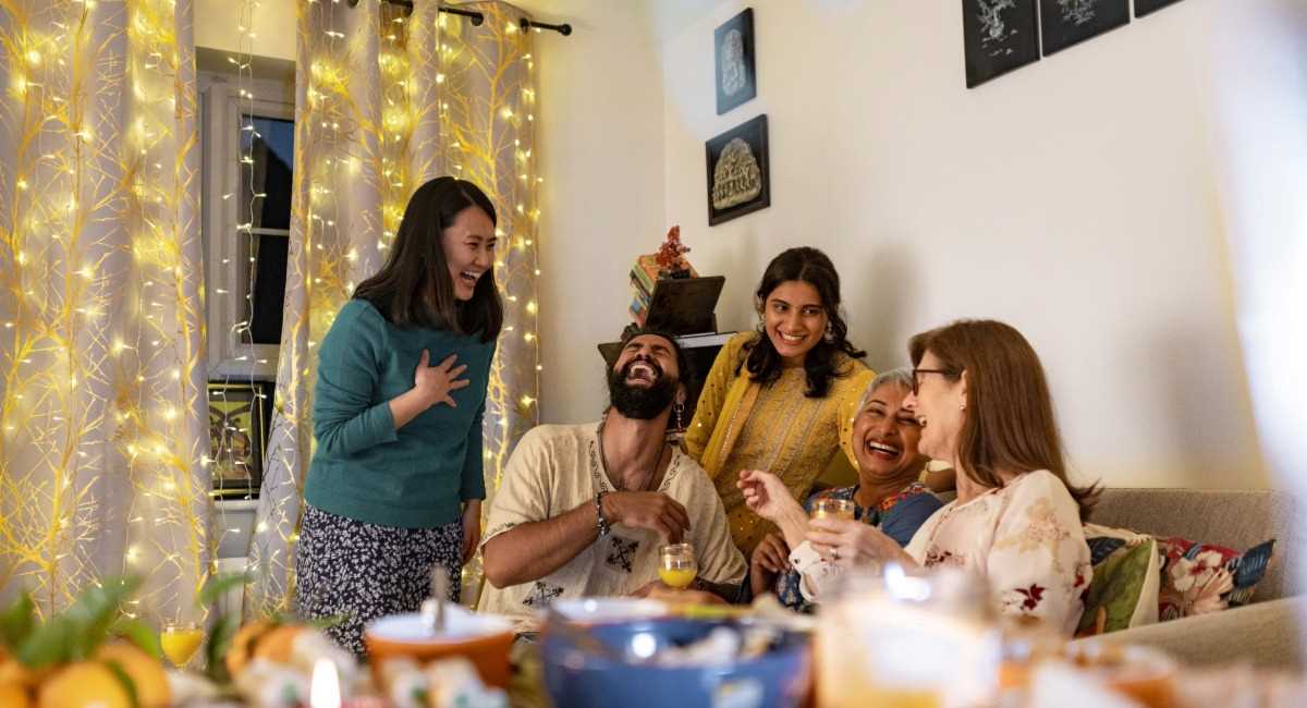 A group of friends sitting in a lounge room laughing