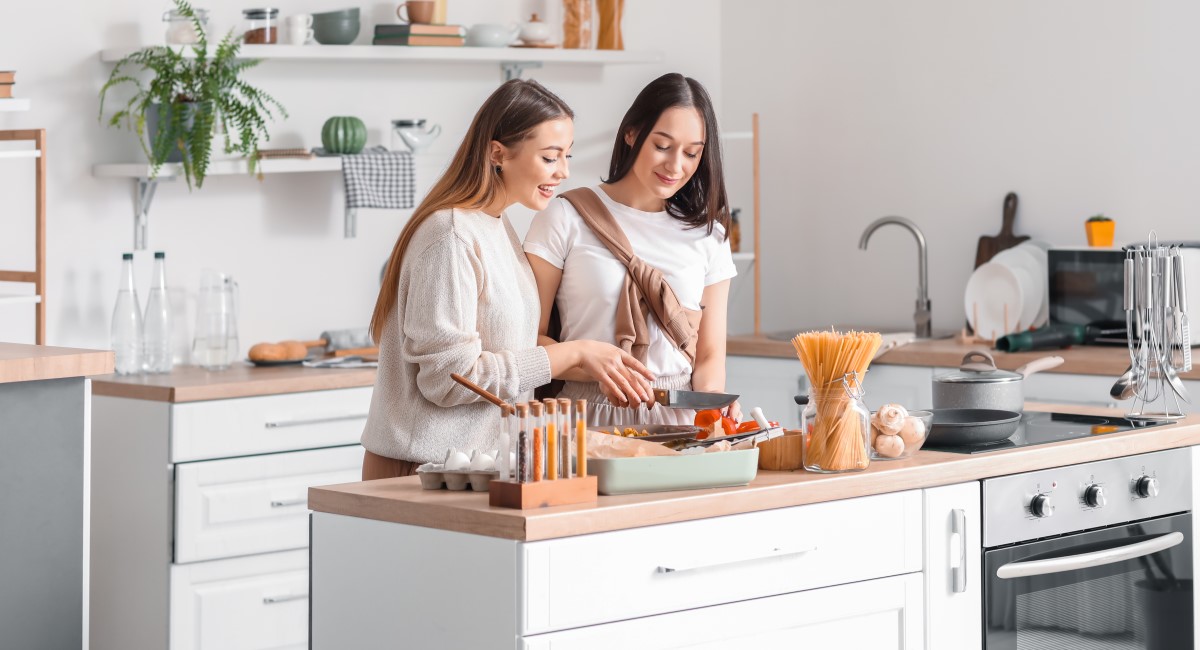 Two women in kitchen, smiling and laughing